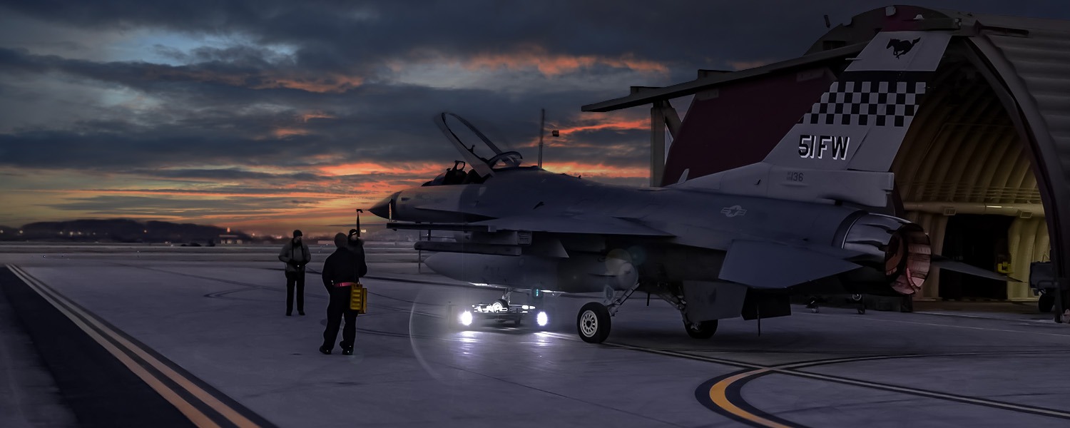 TowFLEXX TF5 MilSpec at Osan Air Base executing a night-time tow of a USAF F-16 jet, demonstrating advanced operational capabilities under low-light conditions.